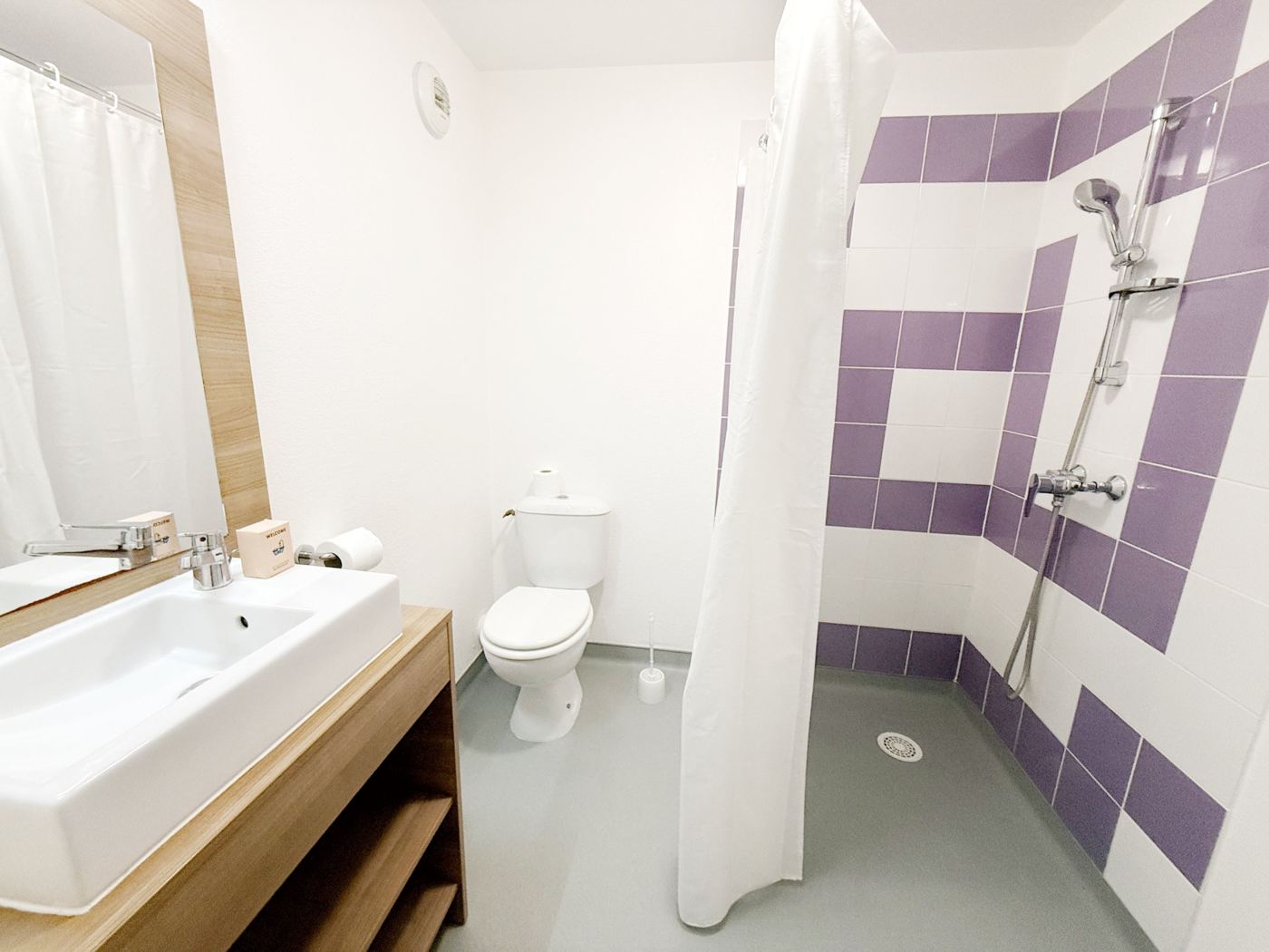 Salle d'eau privative du studio Basic avec douche, lavabo et WC